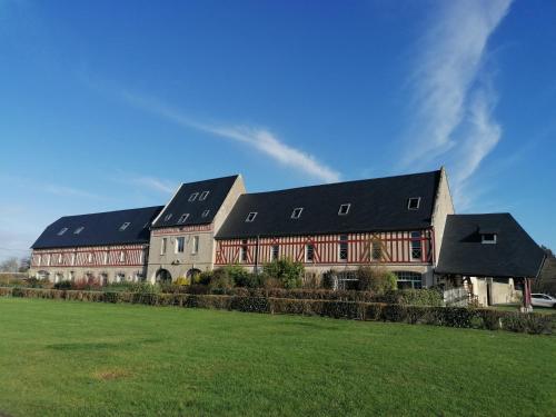 a large building with black roofs and a green field at Nid de pie Grand duplex lumineux cadre verdoyant calme à 5 mn de la mer près Port en Bessin, Bayeux, Omaha Beach, in Commes