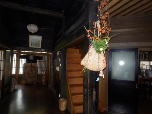 a bag of flowers hanging from a wall in a room at Minshuku Goyomon in Nanto