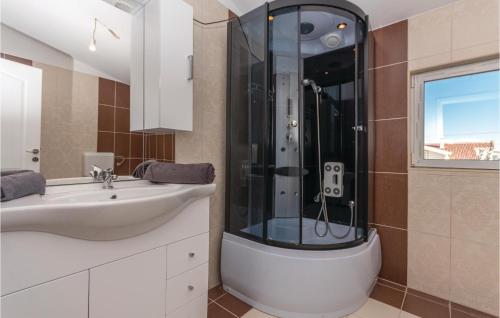 ein Bad mit einer Dusche, einem Waschbecken und einem Waschbecken in der Unterkunft 1 Bedroom Stunning Apartment In Biograd in Biograd na Moru