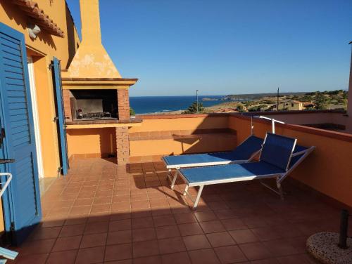 una silla azul en un balcón con chimenea en casa sa ide, en Torre dei Corsari