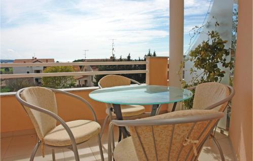 uma mesa de vidro e cadeiras numa varanda em Nice Apartment In Novigrad With Ethernet Internet em Novigrad Istria