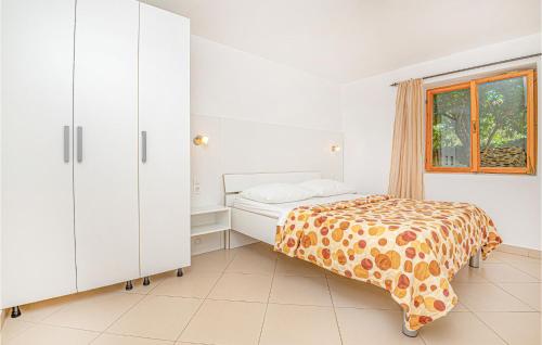 a white bedroom with a bed and a window at Amazing Apartment In Vodice With Kitchen in Vodice