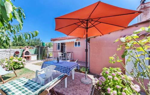 a patio with a table and an umbrella at Awesome Home In Pula With Kitchen in Pula