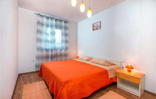 a bedroom with an orange bed and a window at Beautiful Apartment In Fazana With Wifi in Fažana