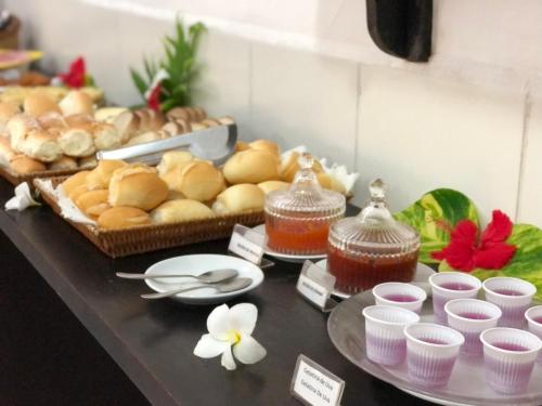 ein Buffet mit Brot und anderen Lebensmitteln auf einem Tisch in der Unterkunft Aguamarinha Pousada in Porto De Galinhas