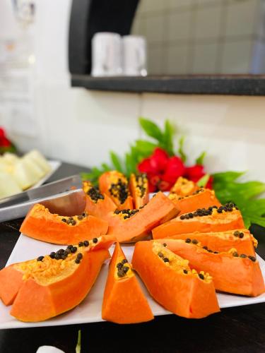 einen Teller mit Lebensmitteln auf einem Tisch mit Obst in der Unterkunft Aguamarinha Pousada in Porto De Galinhas