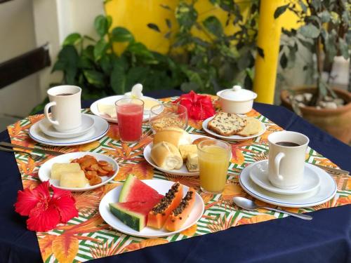 ein Tisch mit Tellern voller Speisen und Getränken in der Unterkunft Aguamarinha Pousada in Porto De Galinhas