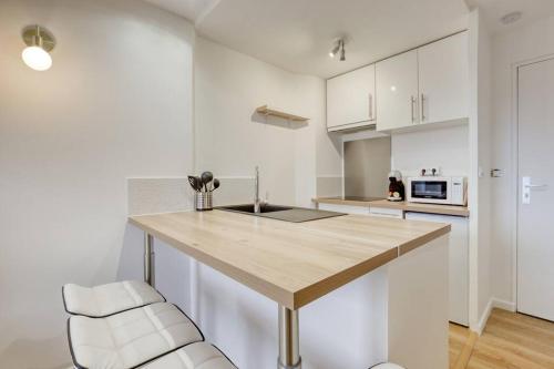 une cuisine avec un comptoir en bois dans une pièce dans l'établissement Très bel appartement 5pers - 3km-8mn Disneyland, à Magny-le-Hongre