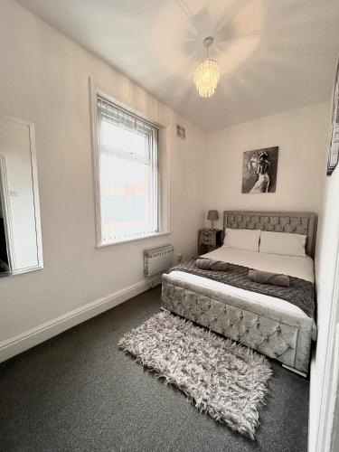 um quarto com uma cama grande e uma janela em Large Luxury Apartment Blackpool em Blackpool