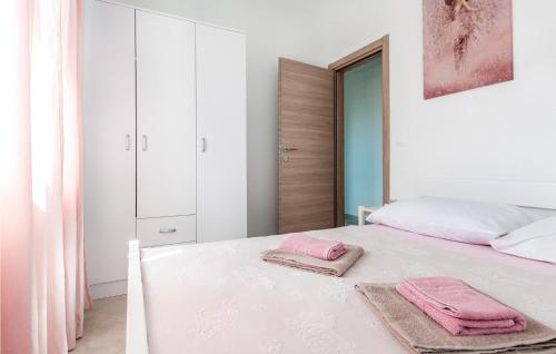 a white bedroom with pink towels on a bed at Gorgeous Apartment In Srima With Wifi in Srima
