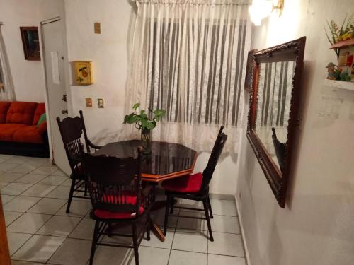 a dining room with a table and chairs and a mirror at Casa Cielo in La Paz