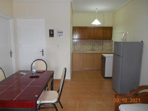 a kitchen with a table and a refrigerator at Melios Rooms in Petalidhion