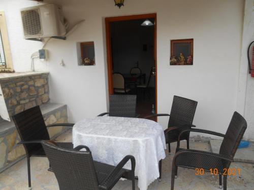 a table and chairs in a room with a fireplace at Melios Rooms in Petalidhion