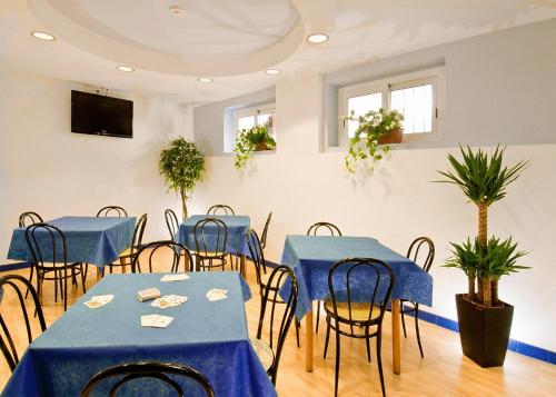 Habitación con mesas azules, sillas y plantas en Hotel Belmar, en Cattolica