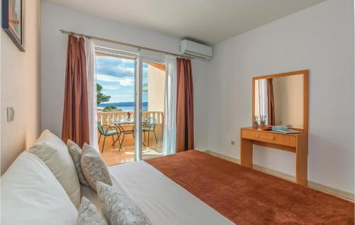 a bedroom with a bed and a view of the ocean at Stunning Apartment In Baska Voda With Wifi in Baška Voda