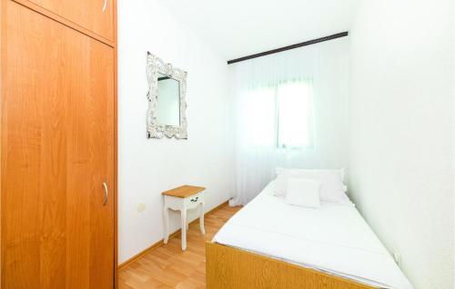 a small bedroom with a bed and a mirror at Awesome Apartment In Sevid With House Sea View in Sevid