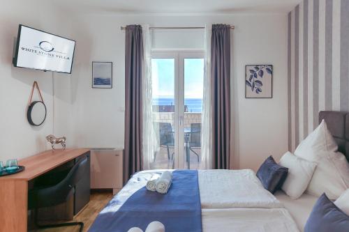 sypialnia z łóżkiem, biurkiem i oknem w obiekcie White Stone Villa 43 w mieście Promajna