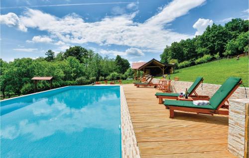 une piscine avec deux chaises longues et une terrasse en bois dans l'établissement Four-Bedroom Holiday Home In Novi Marof, à Novi Marof