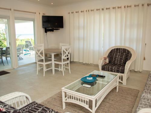 a living room with a table and chairs at Antigua Village Beach Resort in Saint Johnʼs
