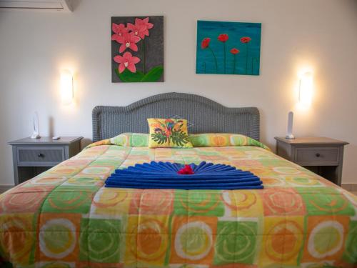 a bedroom with a colorful bed with two night stands at Antigua Village Beach Resort in Saint Johnʼs