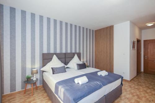 a bedroom with a large bed with two pillows at White Stone Villa 43 in Promajna