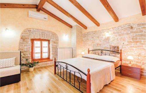 a bedroom with a bed and a stone wall at Lovely Home In Pazin With Wifi in Pazin