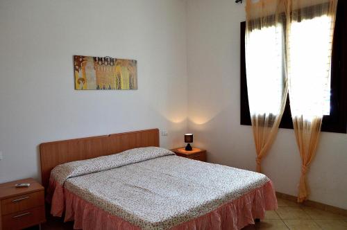een slaapkamer met een bed en een raam bij Appartamento Agrusa in San Vito lo Capo