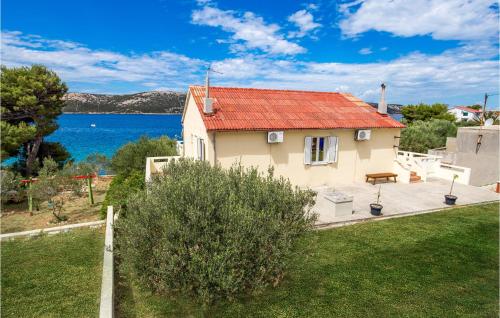 a house with a red roof and a view of the water at 2 Bedroom Awesome Apartment In Stara Novalja in Stara Novalja