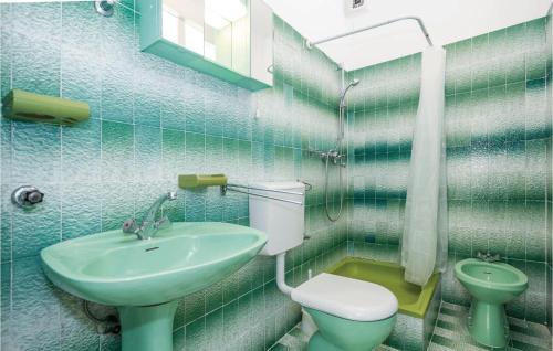 a green bathroom with a sink and a toilet at Stunning apartment in Icici with 1 Bedrooms and WiFi in Ičići