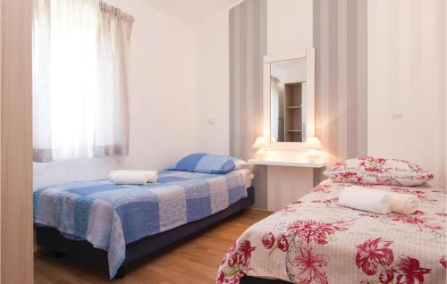 a bedroom with two beds and a mirror at Gorgeous Home In Pula With Outdoor Swimming Pool in Valtura