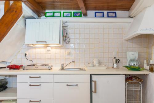 kuchnia z białymi szafkami i zlewem w obiekcie Nikita Traditional House w Chanii