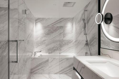 a bathroom with a tub and a sink and a mirror at Hilton Singapore Orchard in Singapore