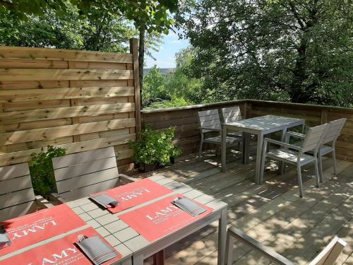 a patio with two tables and chairs and a fence at Hôtel Restaurant Lamy in Troisvierges