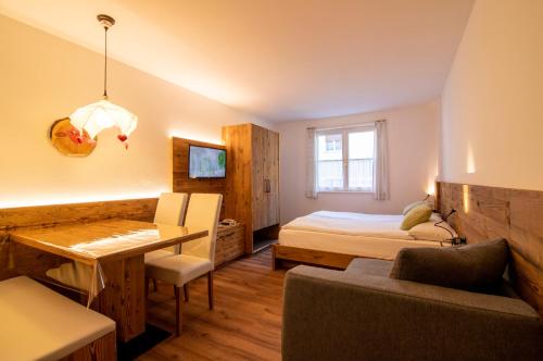 a bedroom with a bed and a desk in a room at Residence Montebel in Tesero