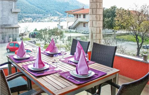 a wooden table with pink napkins and miniature boats on it at Lovely Apartment In Grebastica in Grebaštica