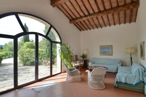 uma sala de estar com um sofá e uma janela aberta em Fattoria il Leccio - Elegant Suite on Florence Hills em Fiesole