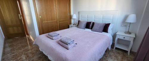 une chambre avec un grand lit blanc avec des serviettes dessus dans l'établissement Casa La Marie POOL KLIMA TV FREE WIFI GARAGE, à Orihuela