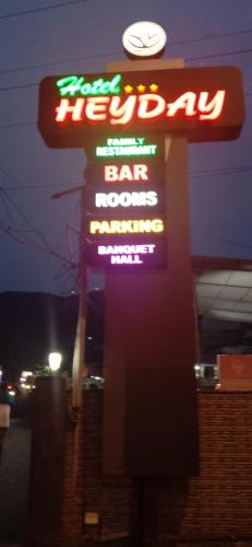 a sign for a bar and restaurant with neon signs at Hotel Heyday in Pathanāmthitta