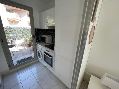 une petite cuisine avec une cuisinière et un micro-ondes dans l'établissement Le Ponteil plage, à Antibes