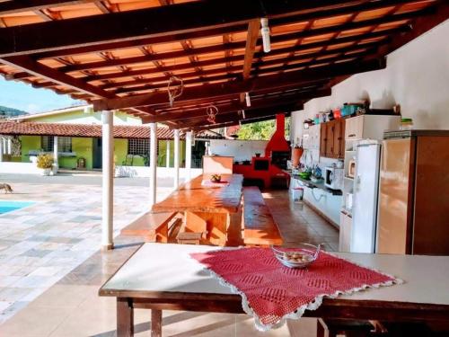a living room with a table and a kitchen at Pousada Recanto Dos Tucanos in Capitólio