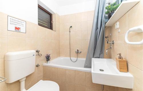 a bathroom with a toilet and a tub and a sink at Two-Bedroom Holiday Home In Trilj in Trilj