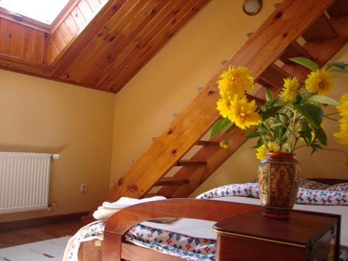 a vase with yellow flowers on a table in a room at Gościniec Koćmierzów in Sandomierz