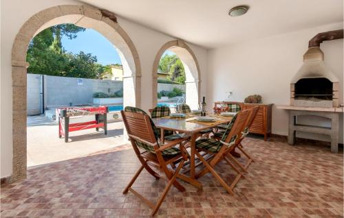 een eetkamer met een tafel en stoelen en een patio bij Cozy Home In Medulin With Sauna in Medulin