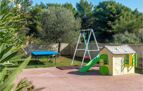 een speeltuin met een glijbaan en een schommel bij Cozy Home In Medulin With Sauna in Medulin