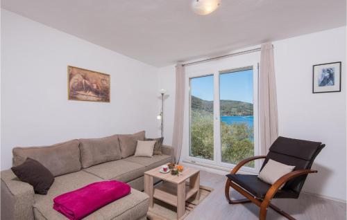 een woonkamer met een bank, een stoel en een raam bij Holiday Home Sokolic Bb Cr in Vela Luka