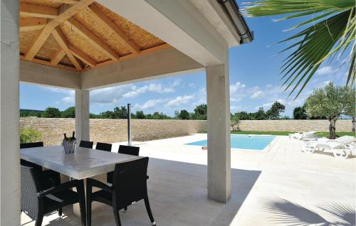 une terrasse avec une table, des chaises et une piscine dans l'établissement Amazing Home In Pridraga With 5 Bedrooms, Wifi And Outdoor Swimming Pool, à Pridraga