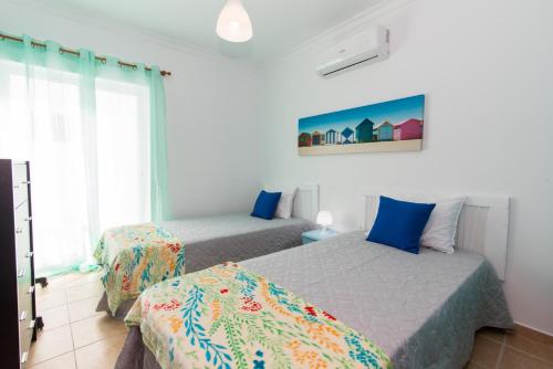 a bedroom with two beds and a window at Apartamento Praia Fuseta 3 - Ria Formosa in Olhão