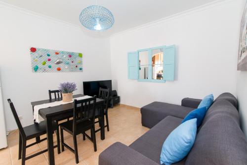 a living room with a couch and a table at Apartamento Praia Fuseta 3 - Ria Formosa in Olhão