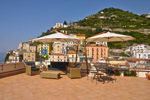 a patio with tables and chairs and umbrellas at La Zinefra Amalfi Dreams in Minori
