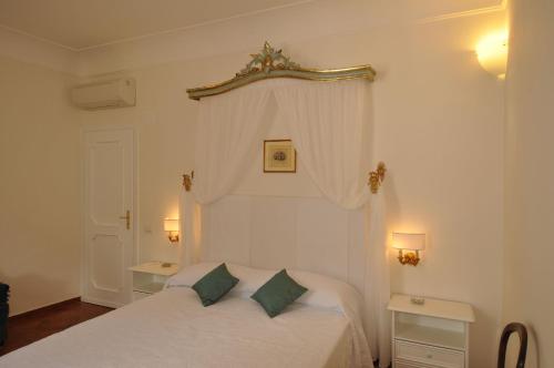 - une chambre avec un lit blanc et 2 oreillers verts dans l'établissement La Zinefra Amalfi Dreams, à Minori